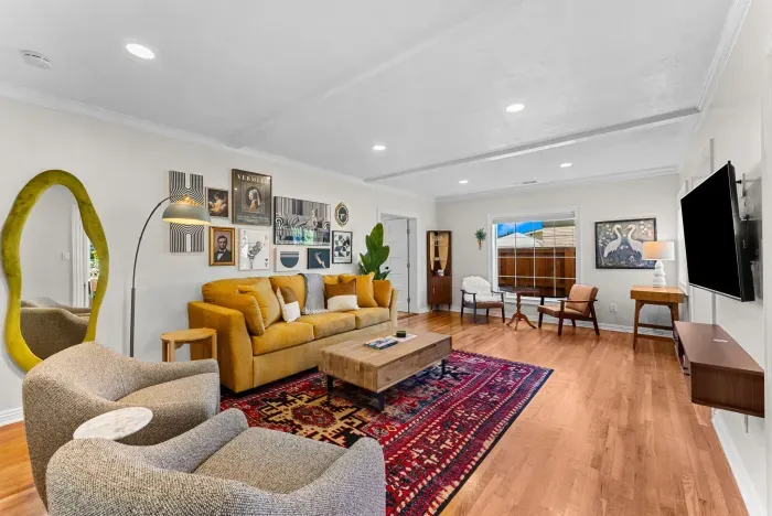 Sunny living room with mid-century style, art wall, and plush seating