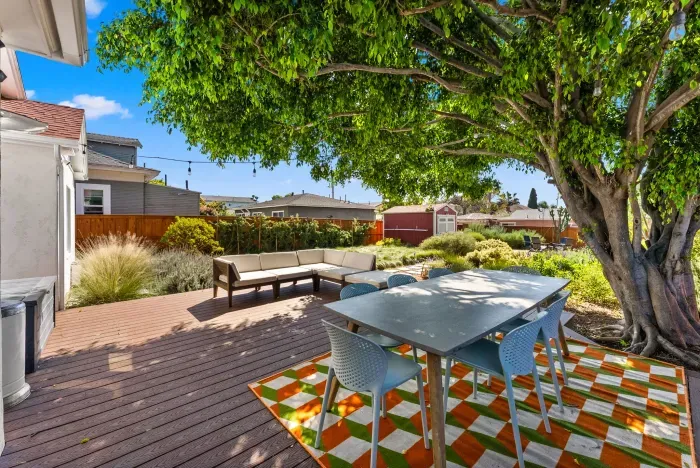 Shaded deck oasis with alfresco dining, lounge seating, and garden views