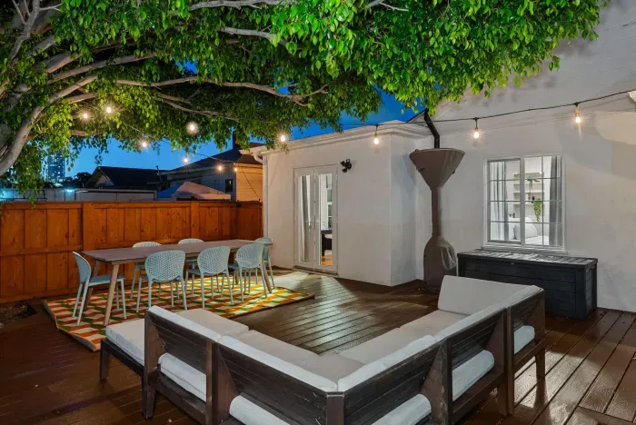 Tree-shaded deck with string lights, alfresco dining and cozy lounge