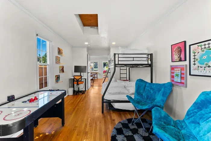 Bright game room with bunk beds, air hockey & workspace—great for families