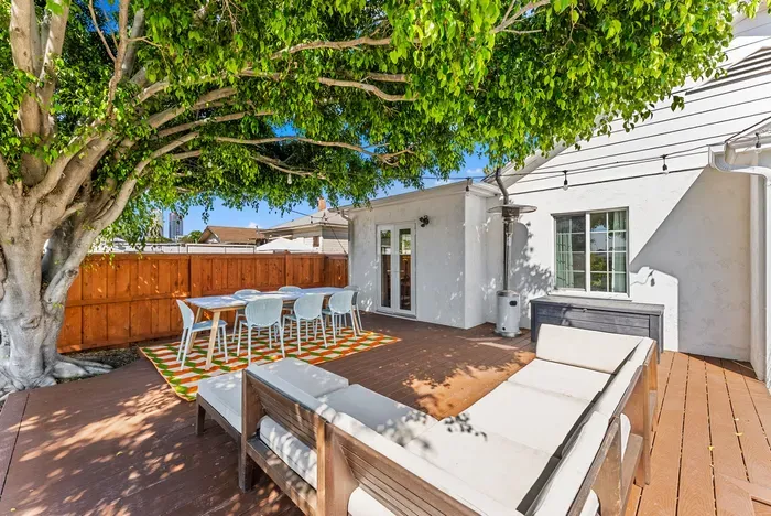 Shaded deck oasis: dining for six, cozy lounge, and string lights.