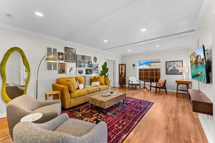 Bright, eclectic living room with gallery wall, plush seating, and smart TV