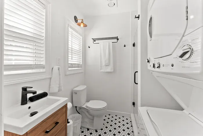 Bright modern bath with walk-in shower and in‑unit washer/dryer