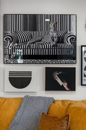 Design-forward lounge with gallery wall and cozy mustard sofa accents