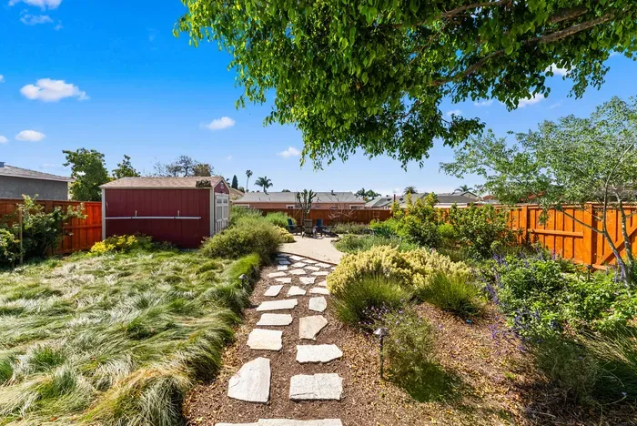 Private landscaped garden with stone path, shade, and seating