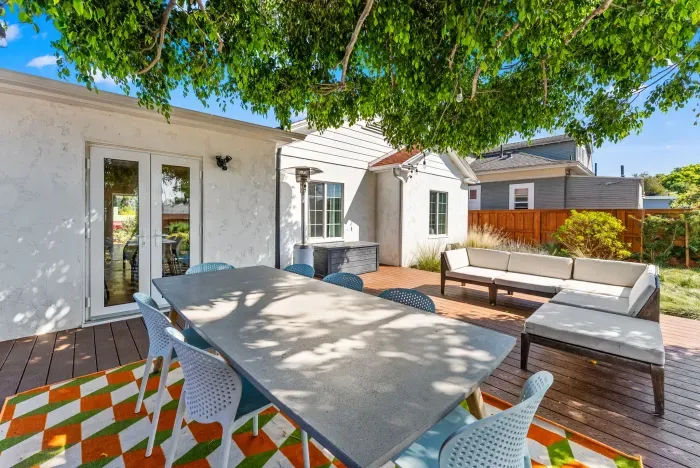 Shaded deck with dining table, lounge seating and heater—ideal alfresco.