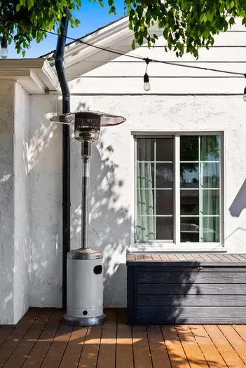 Twinkle-lit deck with patio heater and storage bench for easy evenings.