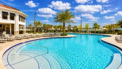Resort-style pool with palm views, loungers, and sunny clubhouse seating