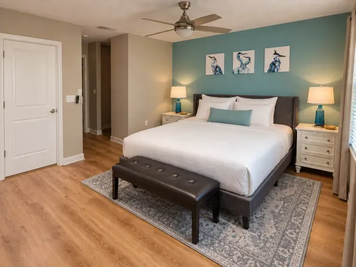 Spacious king bedroom with teal accent wall and stylish coastal decor