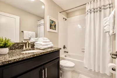 Bright bathroom with granite vanity and full tub/shower combo