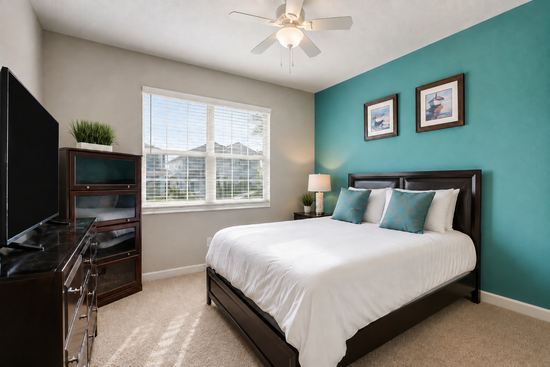 Kingbedroom with dark wood furniture and teal accent wall
