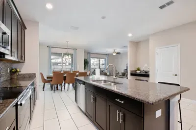 Bright open kitchen with granite island, dining space, and modern finishes