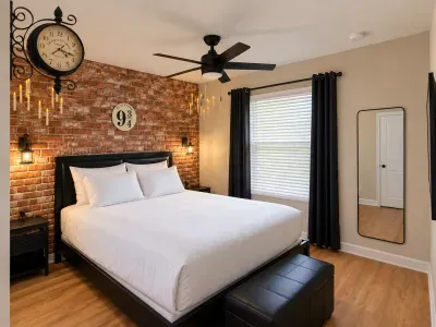Cozy king bedroom with brick accent wall, blackout curtains & stylish lighting