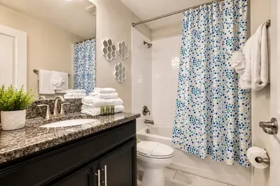 Bright full bathroom with granite vanity and tub-shower combo