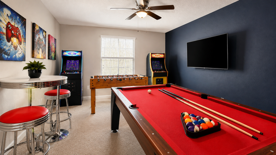 Game room with red-felt pool table, foosball and two arcade machines