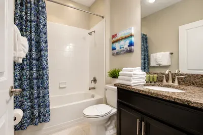Bright full bath with granite vanity and shower-tub combo