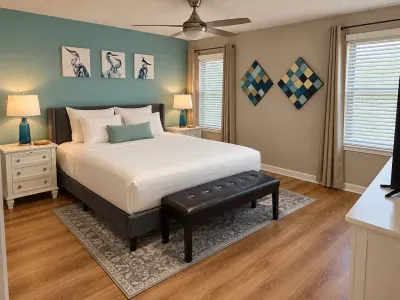 Bright, stylish bedroom with king bed, bench, and calming blue accents