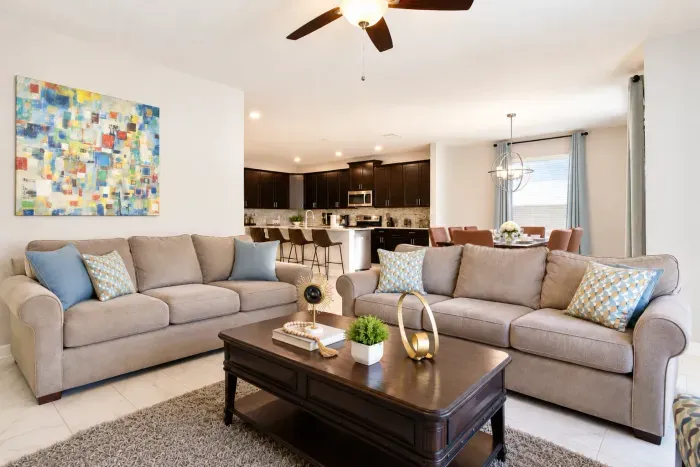 Bright open living room with comfy seating, modern kitchen, and dining area